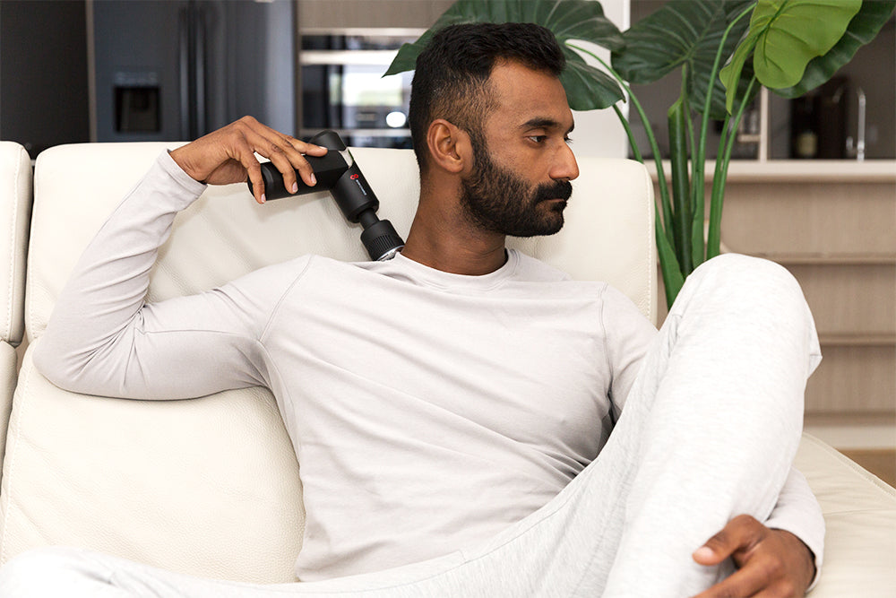 Man Using Cold & Heat Therapy Massage Gun on Neck and Shoulders