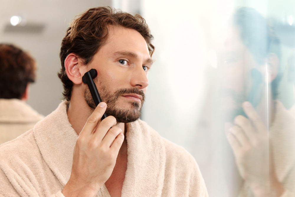 Man Using Red Light Face Wand