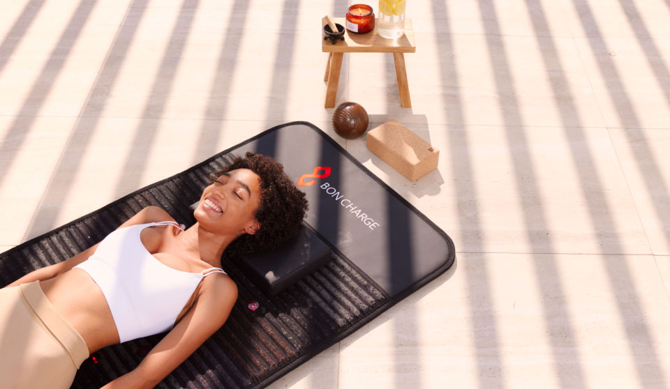 Woman laying on PEMF mat outdoors